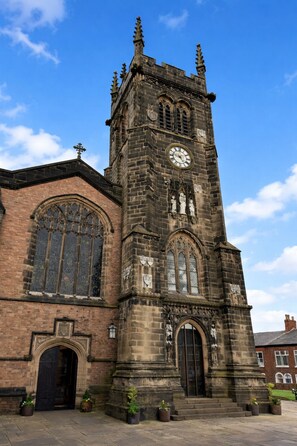 A historic church with a prominent clock tower, arched windows, and a central entrance. - Macclesfield Lodge (Macclesfield)