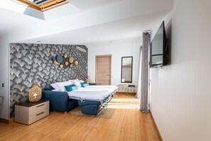 A modern bedroom with a bed, a bedside table, a TV, and a patterned wall.