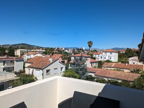 Una zona residencial con techos de tejas rojas, edificios blancos y un cielo azul despejado.
