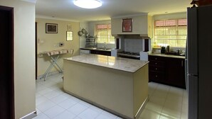 A kitchen with a central island, a stove, and a refrigerator.
