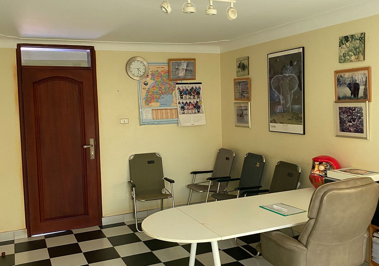 A conference room with a checkered floor, a white table, and four chairs.