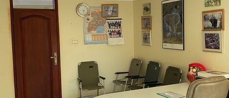 A conference room with a checkered floor, a white table, and four chairs.