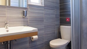 A modern bathroom with a sink, toilet, and shower. - Cozy Apartment with Swimming Pool Near the Sea (Chania)
