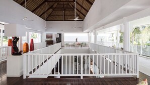 A spacious indoor area with a high ceiling, white railings, and multiple ceiling fans. - Coconut Palms and Endless Blue Skies! (Candidasa)