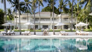 A resort with a pool, lounge chairs, and umbrellas. - Coconut Palms and Endless Blue Skies! (Candidasa)