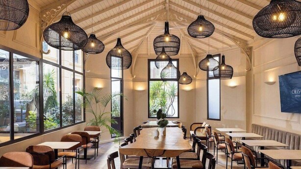 A spacious dining area with high ceilings, large windows, and wicker pendant lighting. - Sonder Yelo Lumiere (Cannes)