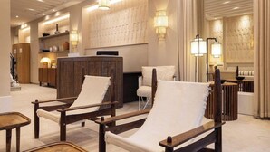 A modern lobby with wooden furniture, wall-mounted lamps, and a reception desk. - Sonder Yelo Lumiere (Cannes)