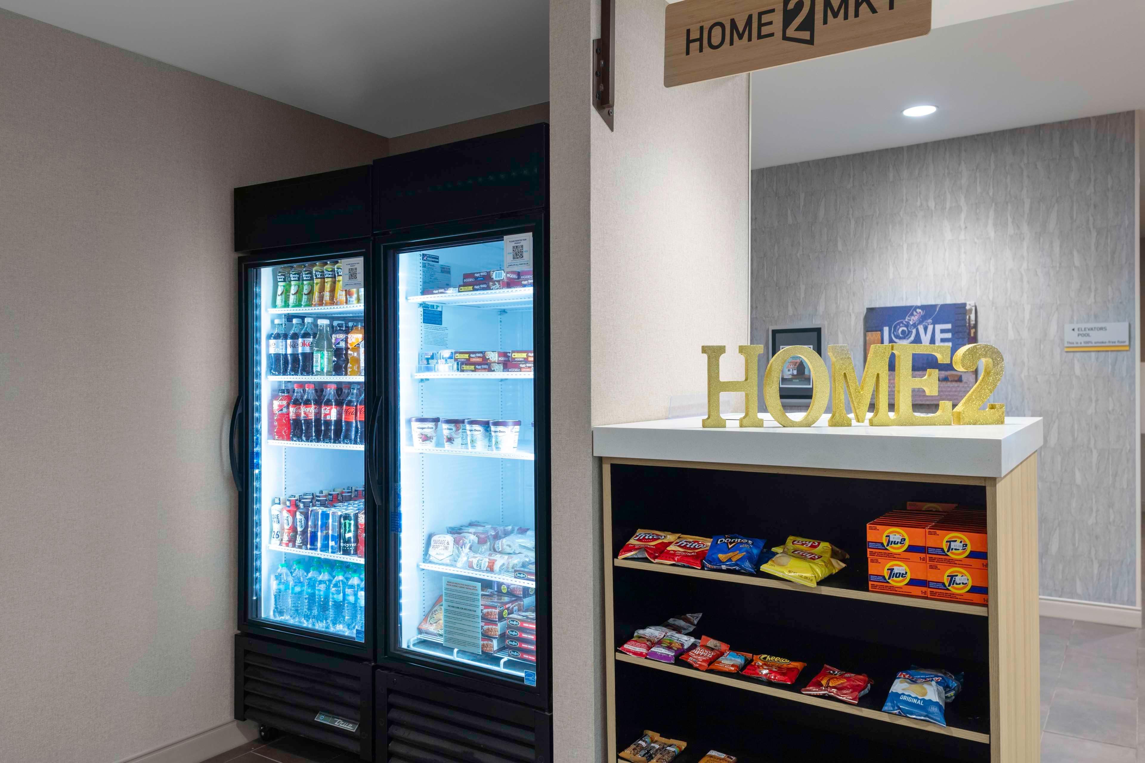 Ein Getränkeautomat mit Snacks und ein Kühlschrank voller Getränke.
