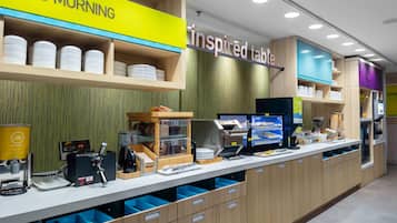Una barra de desayuno con un cartel que dice 'Good Morning', una pantalla digital con el menú e un cartel que dice 'Inspired Table'.