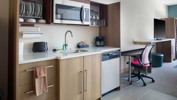 Una cocina moderna con microondas integrado, cafetera y lavavajillas.