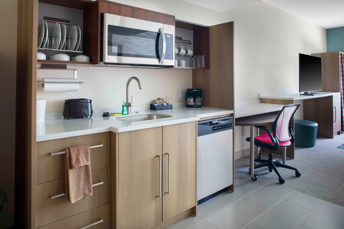 Una cocina moderna con microondas integrado, cafetera y lavavajillas.