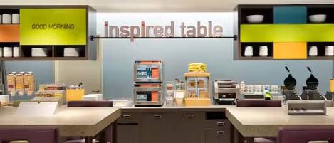 A cafe with a 'Good Morning' sign, a display of breakfast items, and a 'Inspired Table' sign.