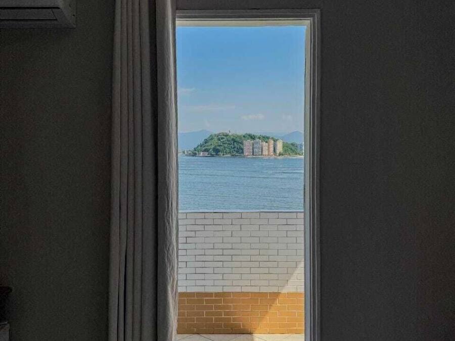 A room with a view of a body of water and a distant island.