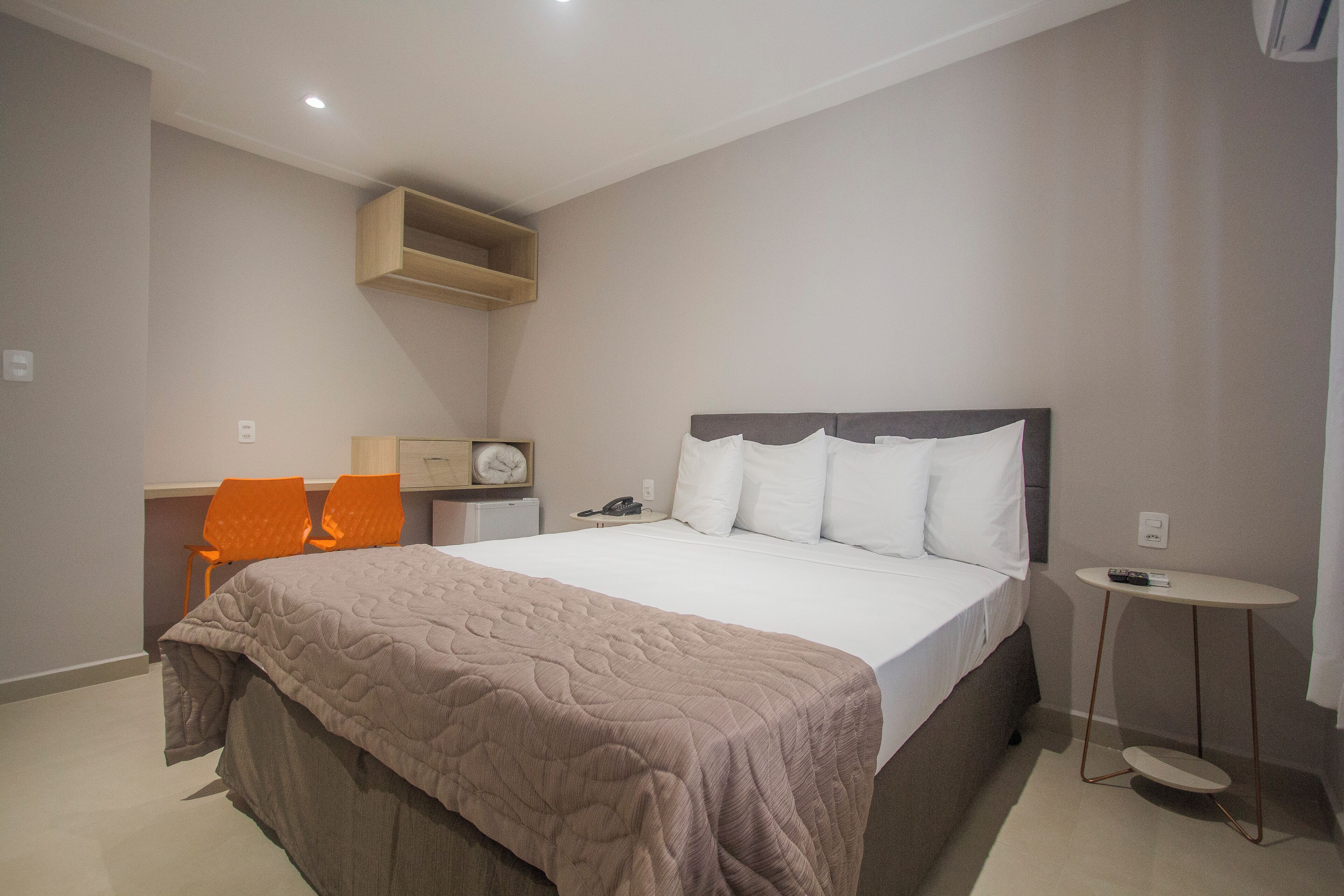 A bedroom with a bed, a desk, and a chair.
