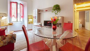 A modern dining area with a glass table, red chairs, and a vase with flowers. - COZY CENTRAL APT CLOSE TO ST PETER BASILICA VATICAN MUSEUMS (Roma)