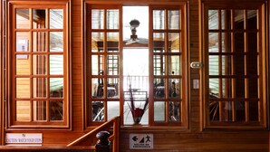 A wooden interior with large windows, a ceiling fan, and a caution sign. - Santa Elena Lodge (Santa Elena)