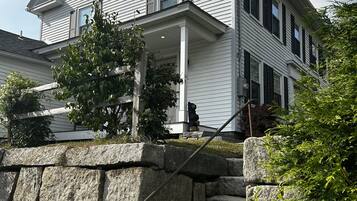 A two-story house with a stone staircase leading to the front porch.