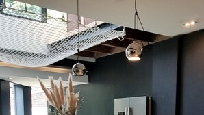 Eine moderne Küche mit einer türkisfarbenen Arbeitsplatte, einem Kühlschrank und hängenden Pendelleuchten.