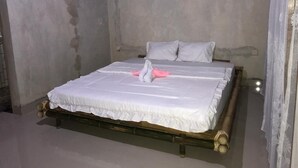 A single bed with a wooden frame and white bedding. - Melody (Jerowaru)
