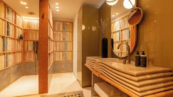 Un baño con tocador, espejo y estanterías.