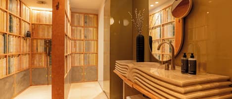 Un baño con tocador, espejo y estanterías.
