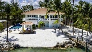 A beachfront property with a pool, a covered area, and a sandy beach. - Keys home overlooking the ocean and beautiful sunrises! (Islamorada)