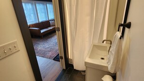 A bathroom with a shower curtain, a sink, and a toilet.
