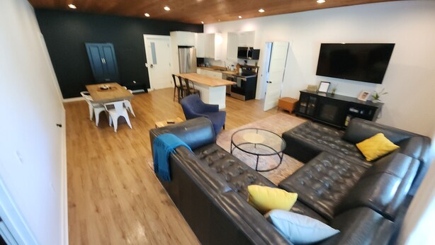 A modern living room with a sofa, coffee table, and dining area.