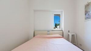 A bedroom with a single bed, a window with a view of greenery, and a white ladder against the wall. - 3826 Sabbiabianca - Aptm C by Barbarhouse (Porto Cesareo)