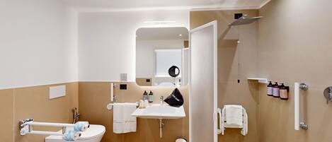 Un baño moderno con bañera, lavamanos, inodoro y zona de ducha.
