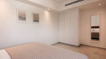 A modern bedroom with a bed, a wardrobe, and two framed pictures on the wall.