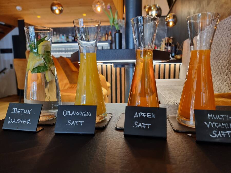 Cuatro botellas de vidrio con etiquetas sobre una mesa en un restaurante.