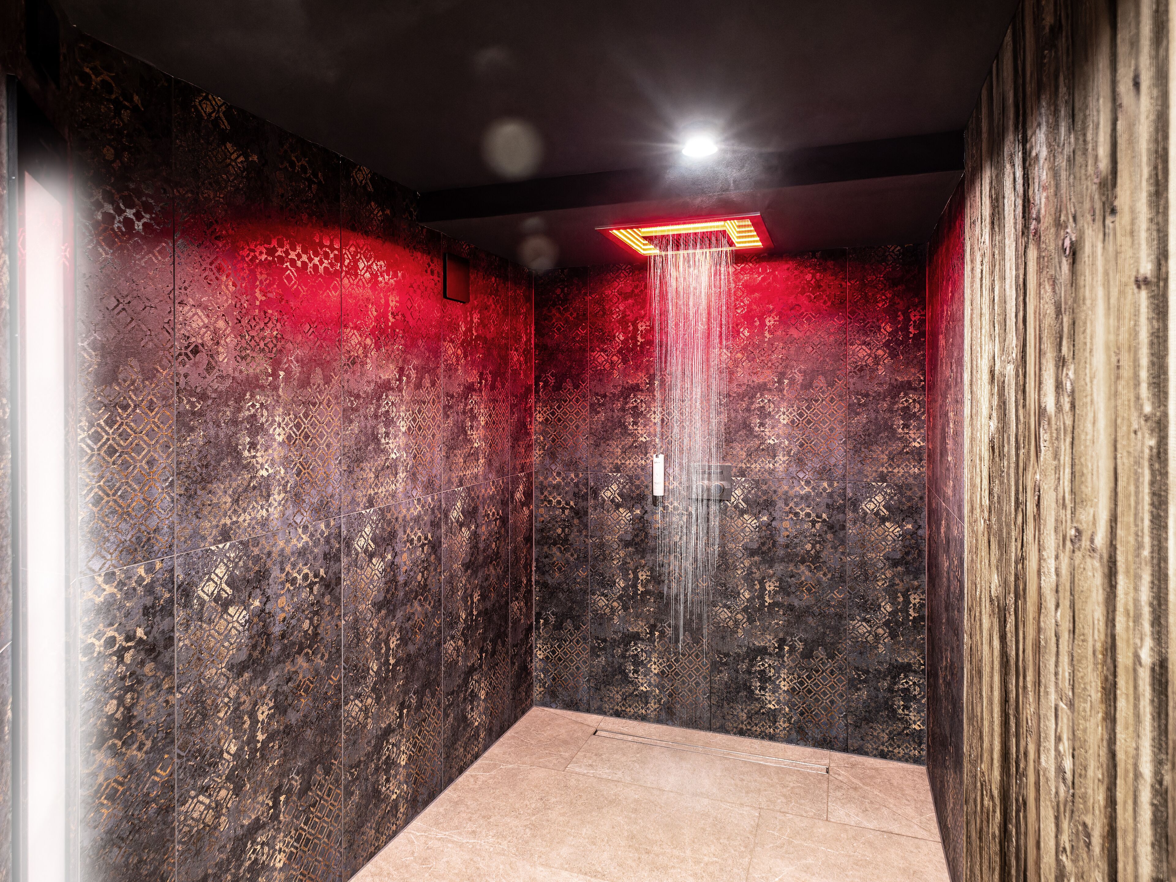 A modern shower with a unique design, featuring a textured wall and a central water feature.