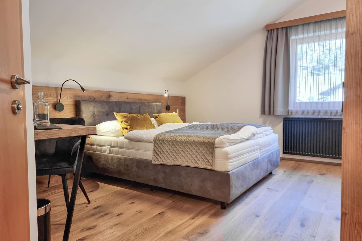 Un dormitorio con una cama, un escritorio y una silla.