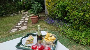 Ein Tisch mit einer Champagnerflasche, einem Glas roter Flüssigkeit und einer Schüssel Chips.