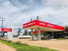 Señal de Hotel American con un toldo rojo y una base blanca.