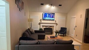 A living room with a sectional sofa, a fireplace, a television, and a coffee table.