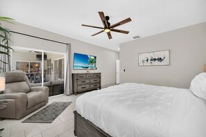 A bedroom with a bed, a ceiling fan, a dresser, and a painting. - EV_5334 - 4 Bed 3 Bath Home with Screened-in Pool, Games Room, Kids Bedrooms (Kissimeee)