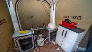 Una tienda compacta con kitchenette, que incluye estufa a gas, un lavamanos y un refrigerador pequeño.