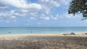 Una playa con cielos despejados y aguas tranquilas.