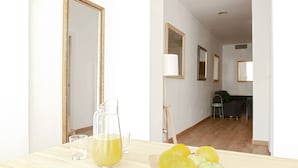Een kamer met een houten tafel, een karaf met gele vloeistof en een glas. Er liggen citroenen op de tafel, en een spiegel aan de muur.