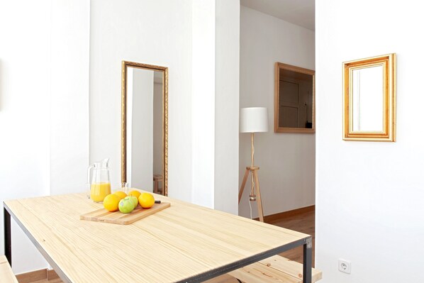 Une chambre moderne avec une table en bois, un miroir et une lampe.