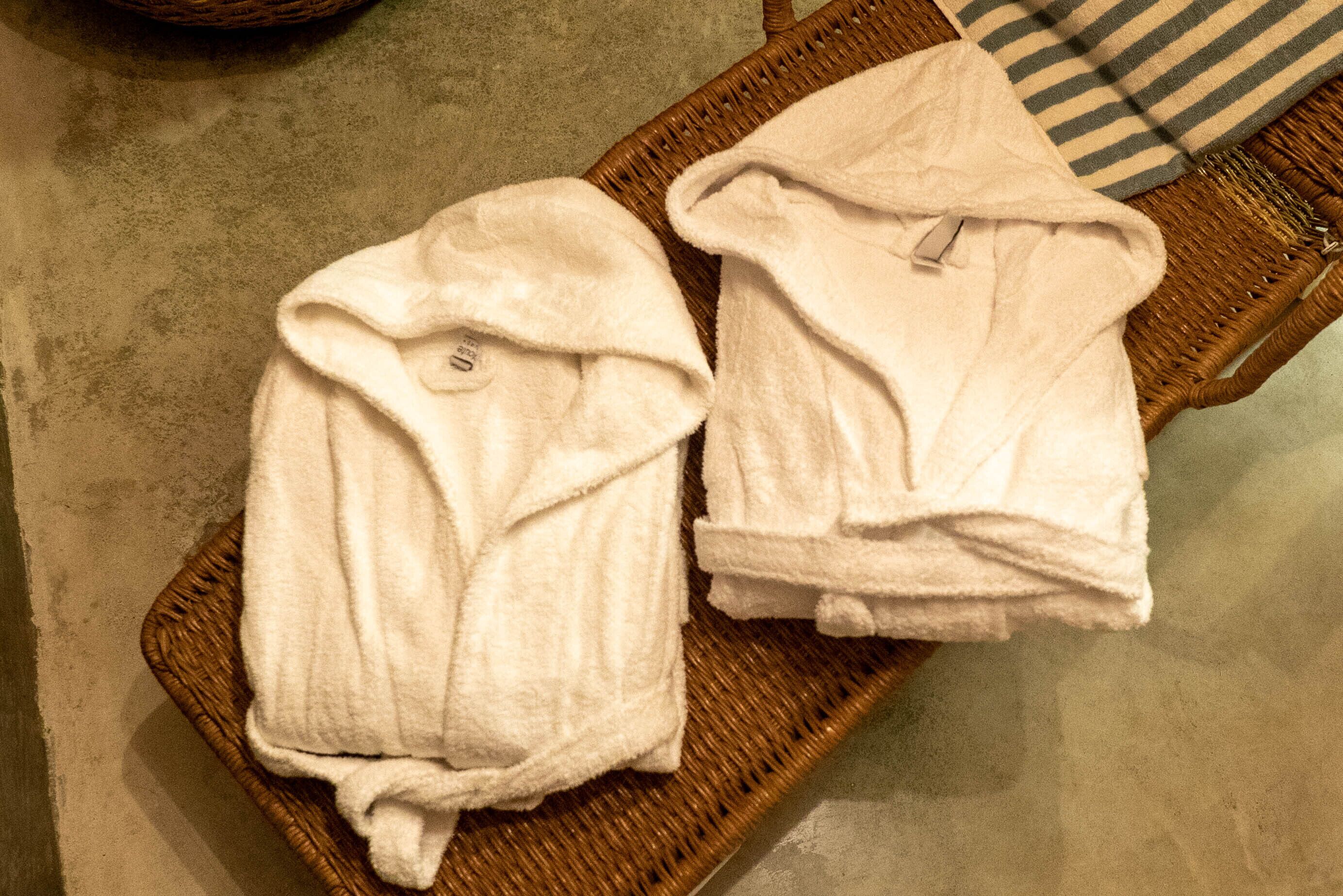 Two white towels on a wicker tray.