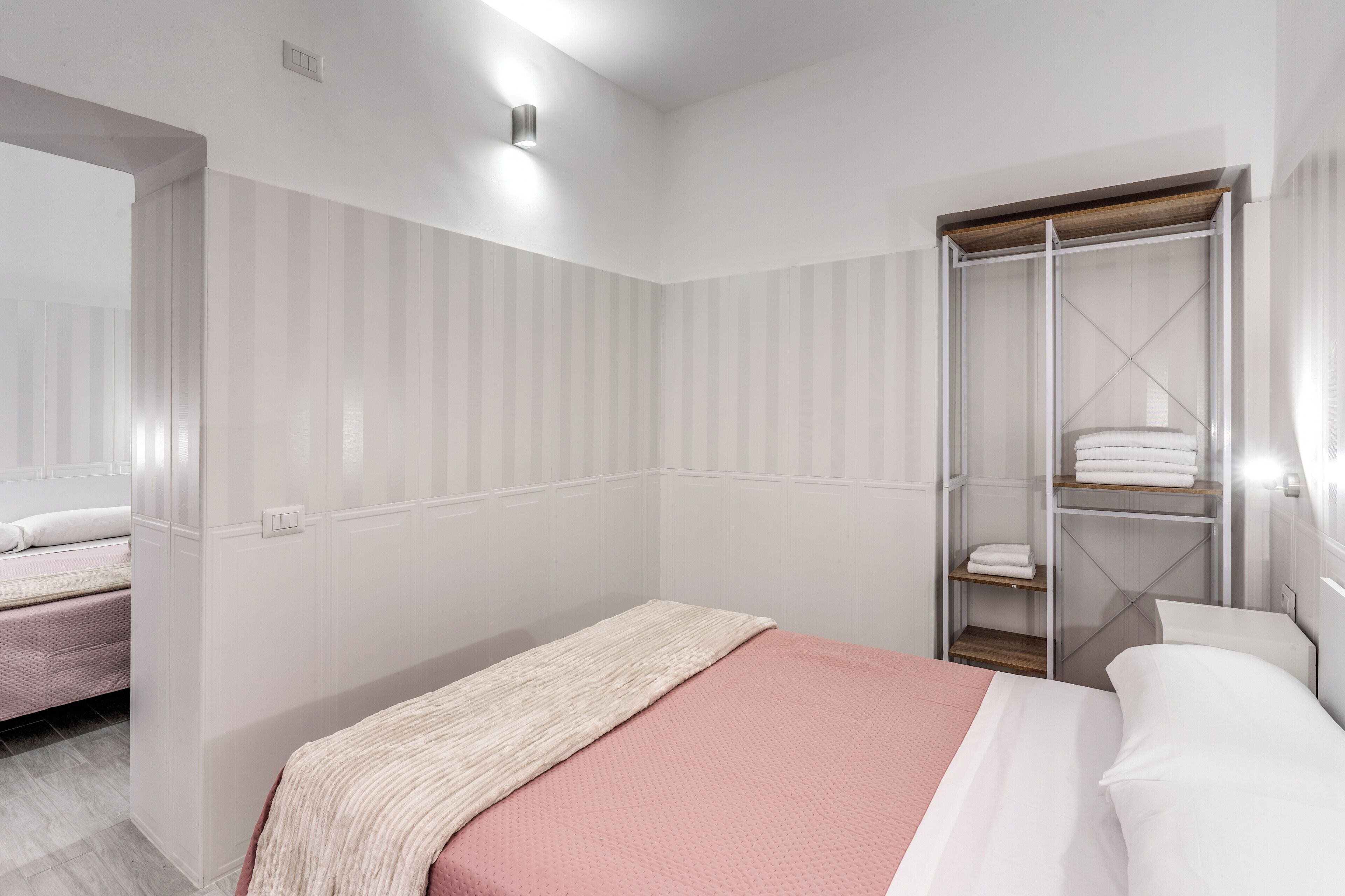A bedroom with a bed, a wardrobe, and a mirror.