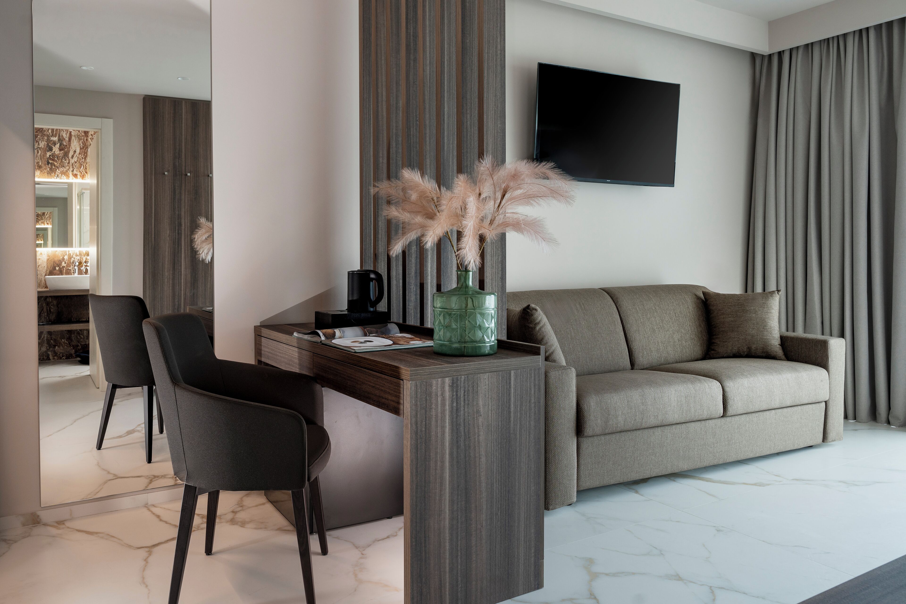 Uma sala de estar moderna com um sofá, uma mesa de centro e uma TV fixada na parede.