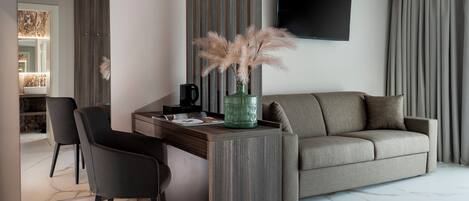 A modern living room with a sofa, a coffee table, and a TV mounted on the wall.