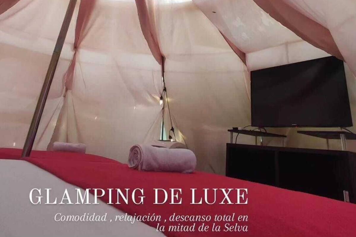 Une pièce en forme de tente, avec un lit, une télévision et une lampe.