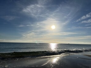 Une plage avec des vagues et un ciel dégagé.