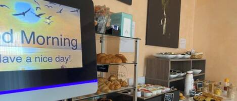 A breakfast buffet with various pastries and a sign that reads "Good Morning Have a nice day!"