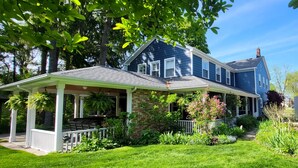 A two-story house with a covered porch and a brick foundation. - Royal Manor Inn (Niagara-on-the-Lake)